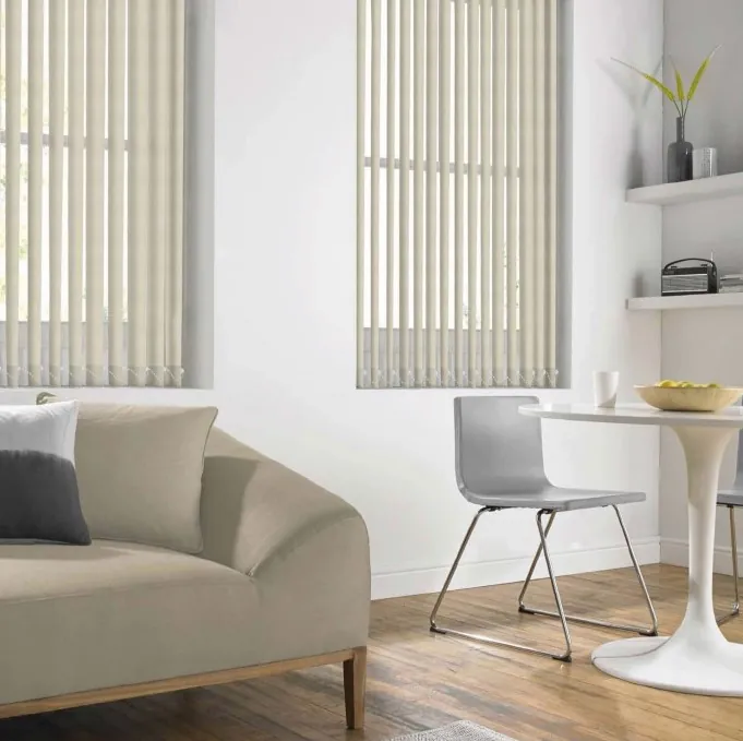 Cream vertical blinds on tall windows in a modern dining room.